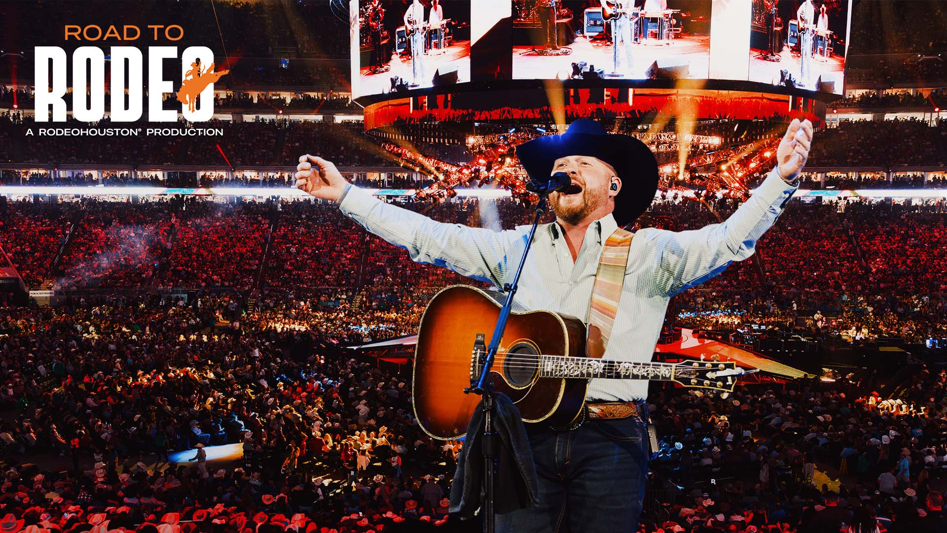 Cowboy singer with guitar on a large arena stage, arms raised, crowd cheering; 'ROAD TO RODEO' banner visible above.